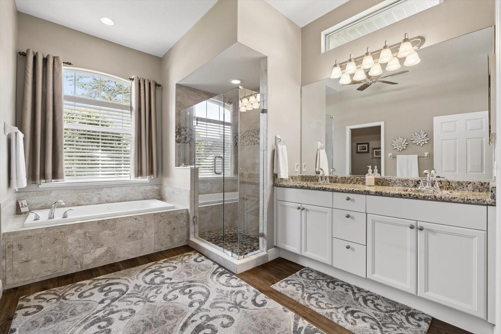 Primary Bathroom with dual sinks, tub and walk in shower
