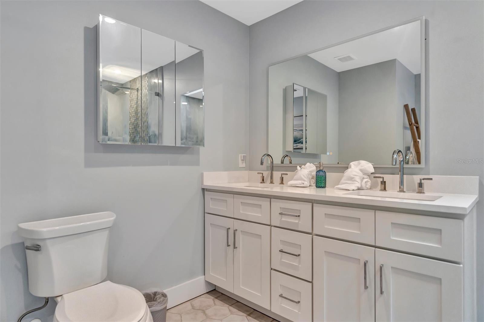 Spacious primary ensuite with double vanity and walk-in rain shower.