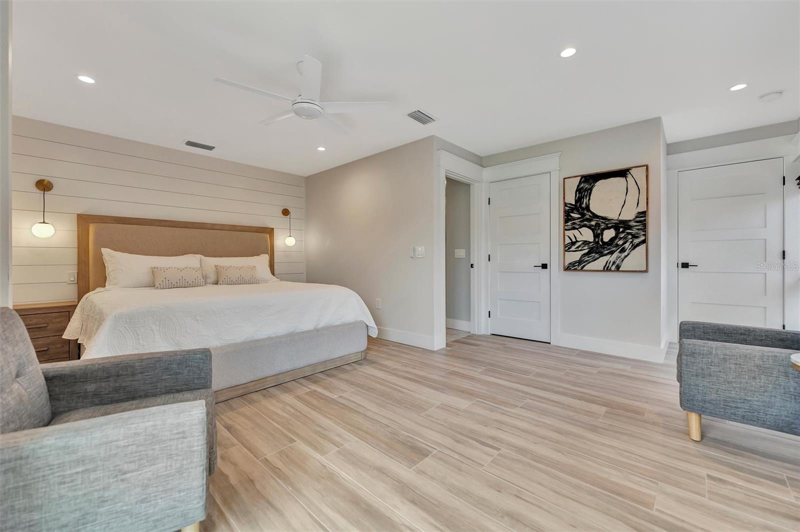 Primary suite with sliding glass doors, gorgeous views of the pool, turf area, and canal, plus an ensuite bathroom.