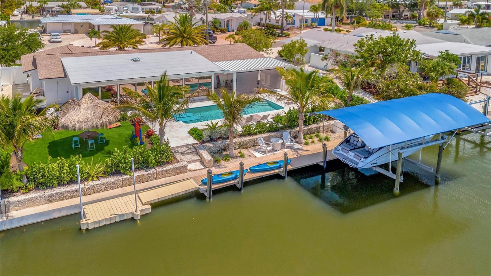 Approximately 90 feet of waterfront, updated seawall, composite dock, floating kayak/paddleboard dock, and covered 10,000-lb remote boat lift.