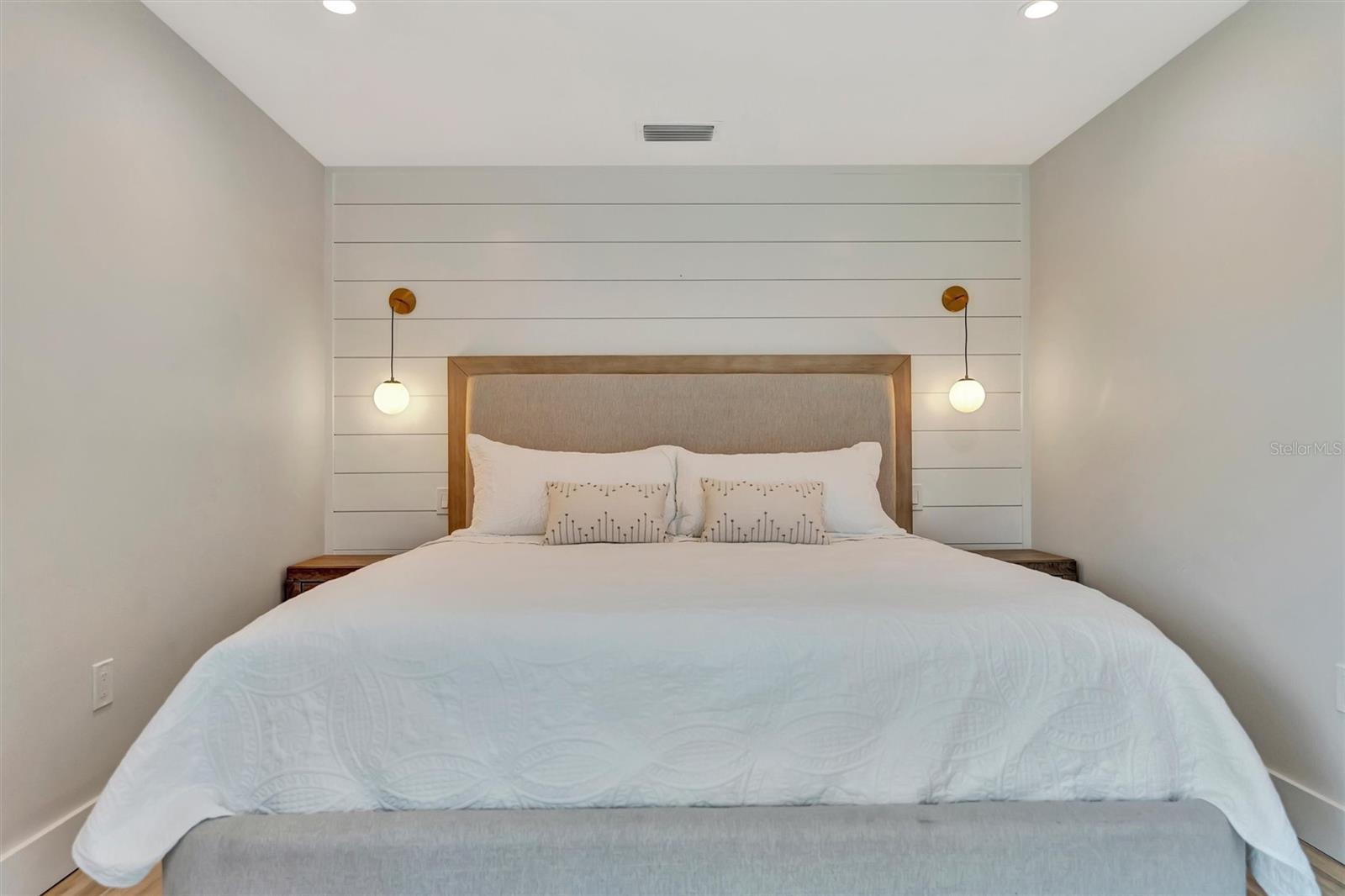 Primary suite with sliding glass doors, gorgeous views of the pool, turf area, and canal, plus an ensuite bathroom.