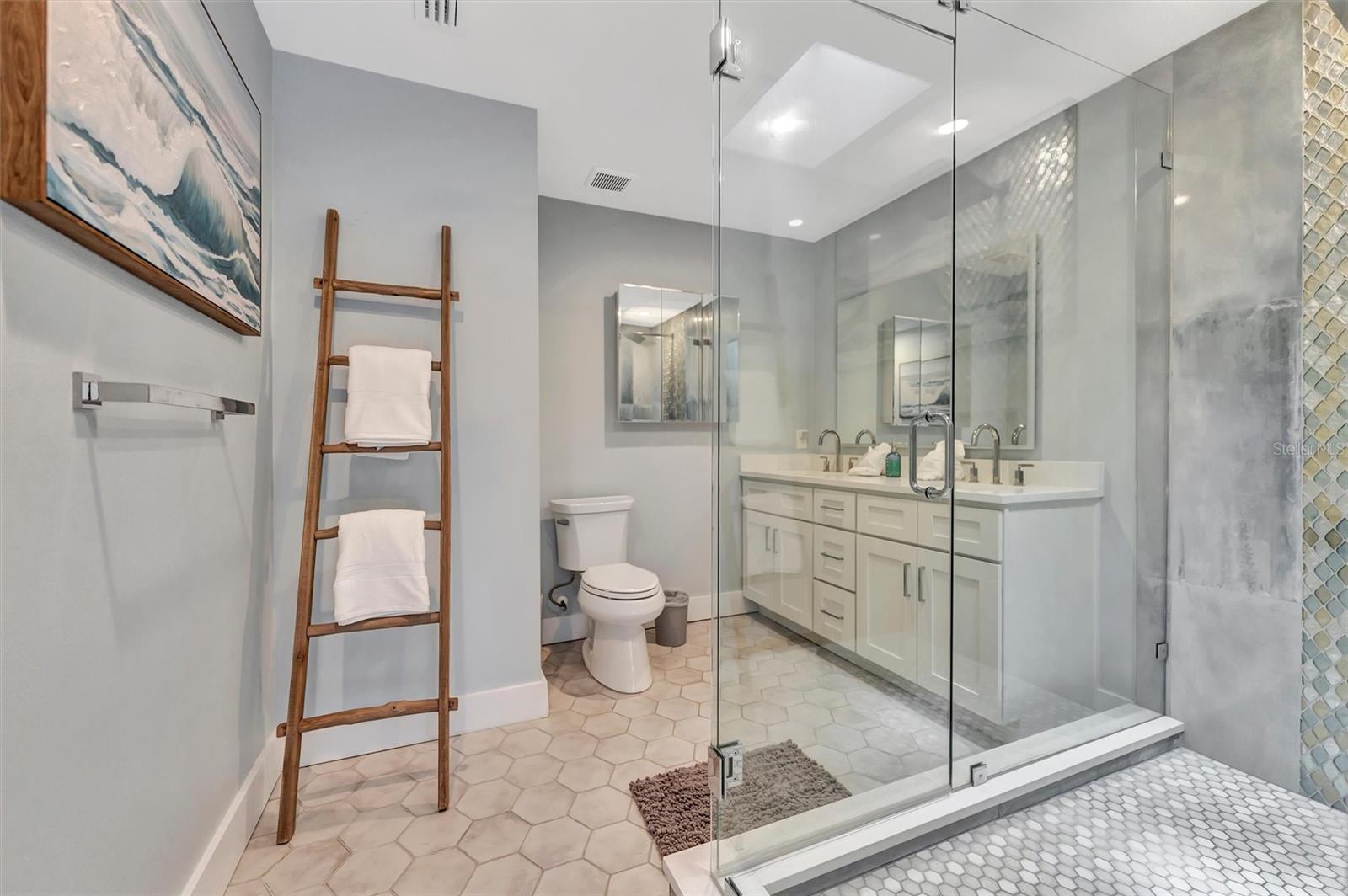 Spacious primary ensuite with double vanity and walk-in rain shower.