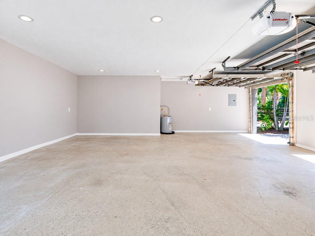 Another view of the extended three-car garage, showcasing the impressive open floor area and additional space for storage, a workshop or car enthusiast needs.