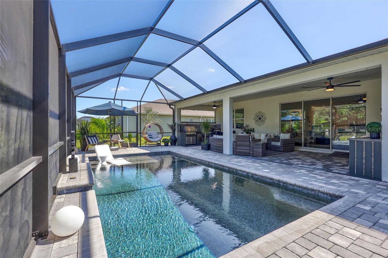 Florida living with a sun shelf, expansive Pave Lanai (deck), Premium PebbleTec Finish with inviting lounge areas and kitchen!