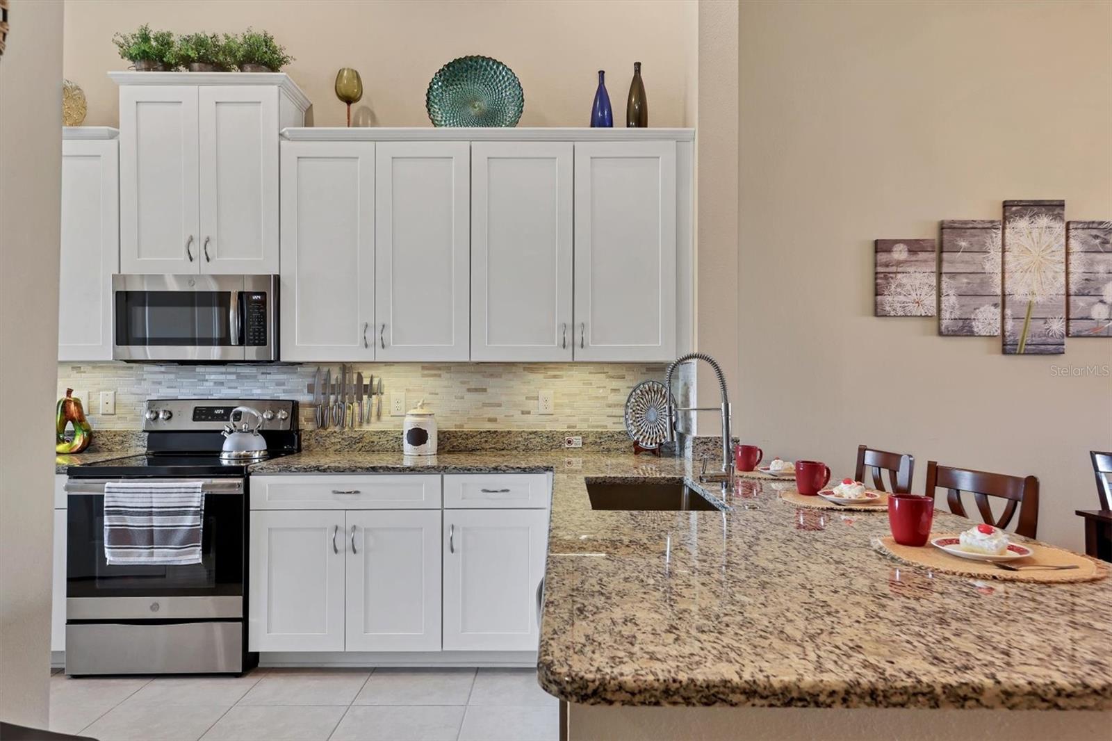 Granite Counters, stainless applicances and tall wooden cabinetry