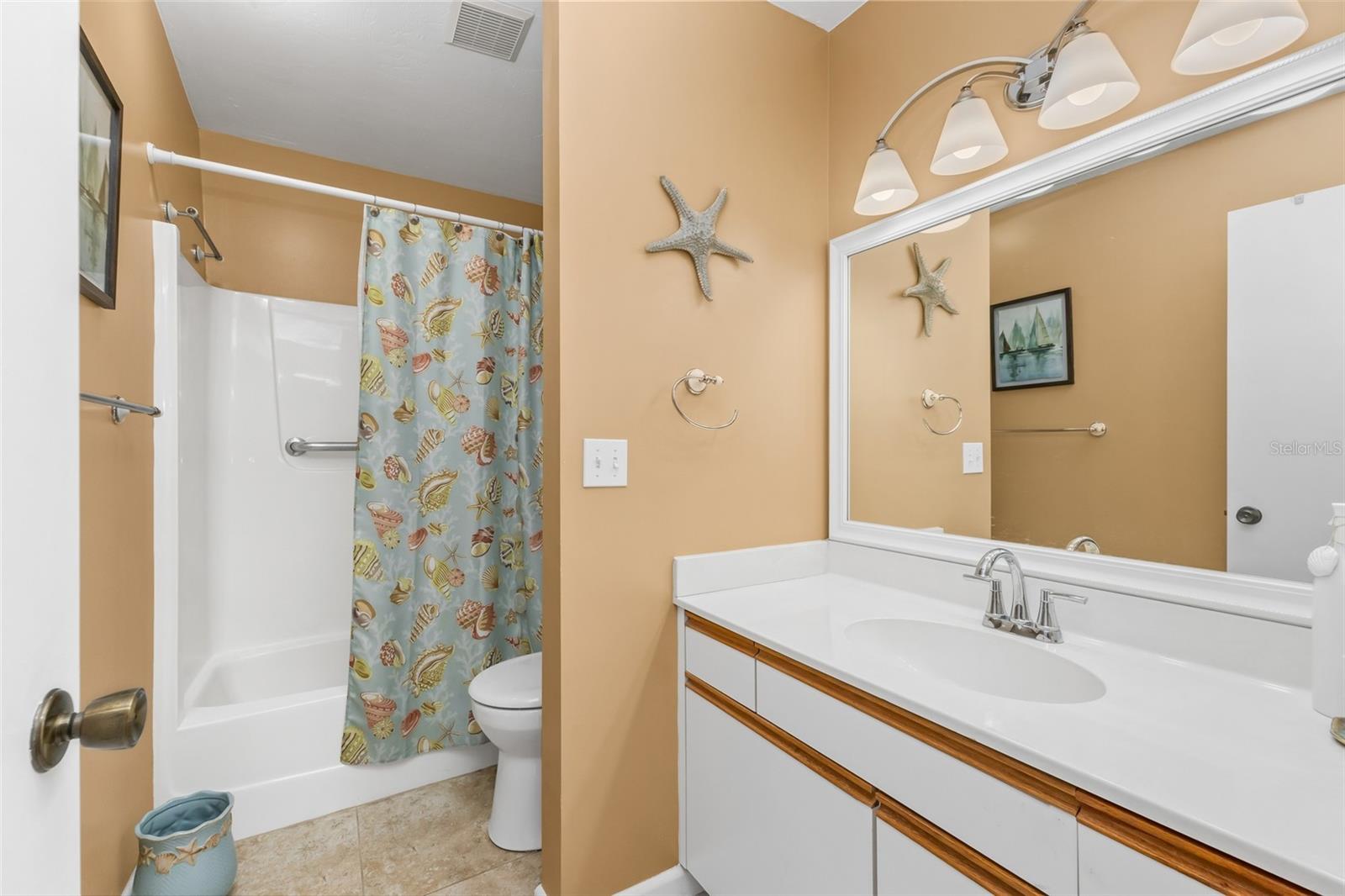 The private primary bath offers a spacious vanity with generous counter space, a large wall mirror and a tub/shower combinationall conveniently tucked within the primary suite.