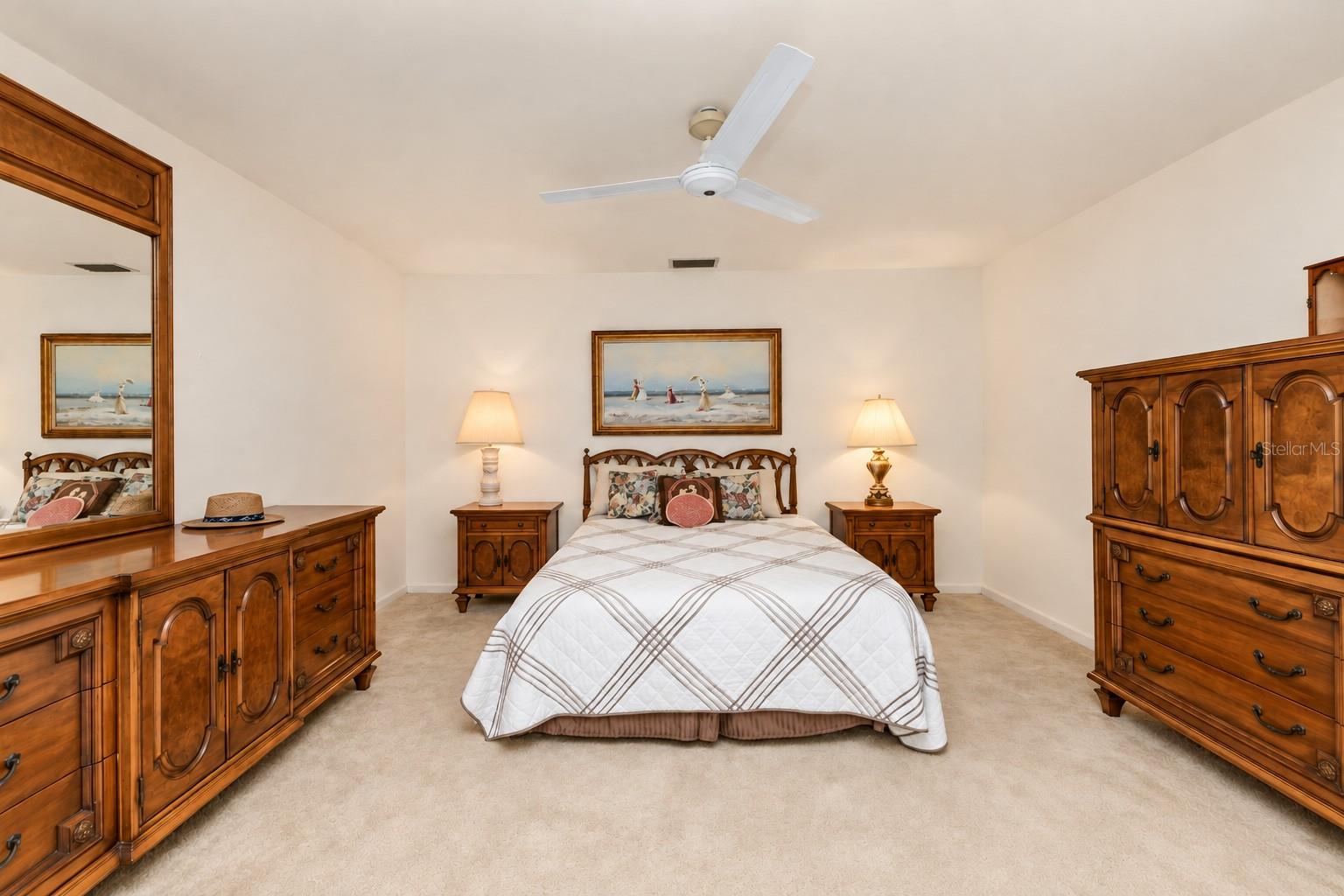 Primary bedroom (bed room 1) with double closets, ceiling fan, ensuite bathroom (shower only), and sliders to waterfront backyard.