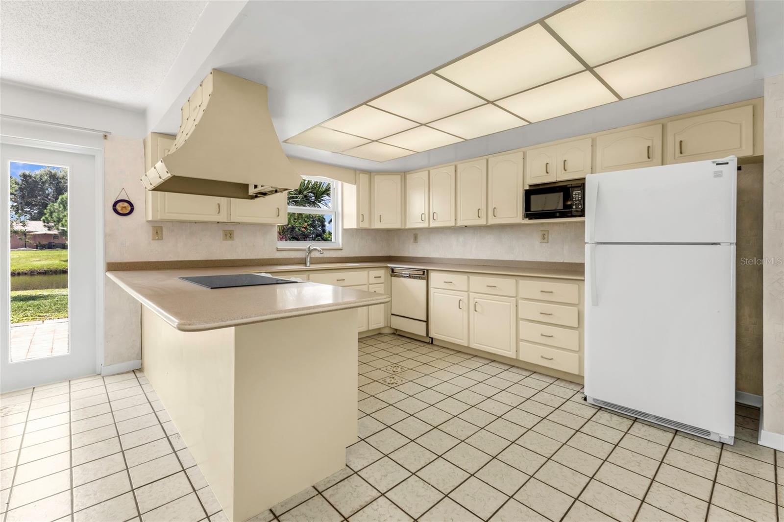 Kitchen with window views to your waterfront backyard and doorway to the back patio.