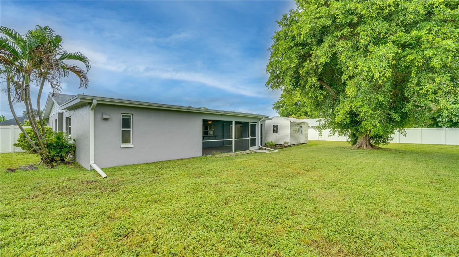 Enjoy the expansive 3-lot backyard with mature landscaping, a new white privacy fence, and a detached storage shed.