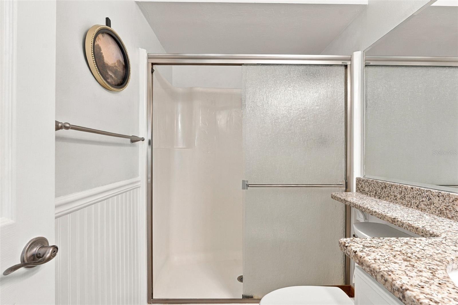 Spacious Walk-In Shower with Granite Top Vanity