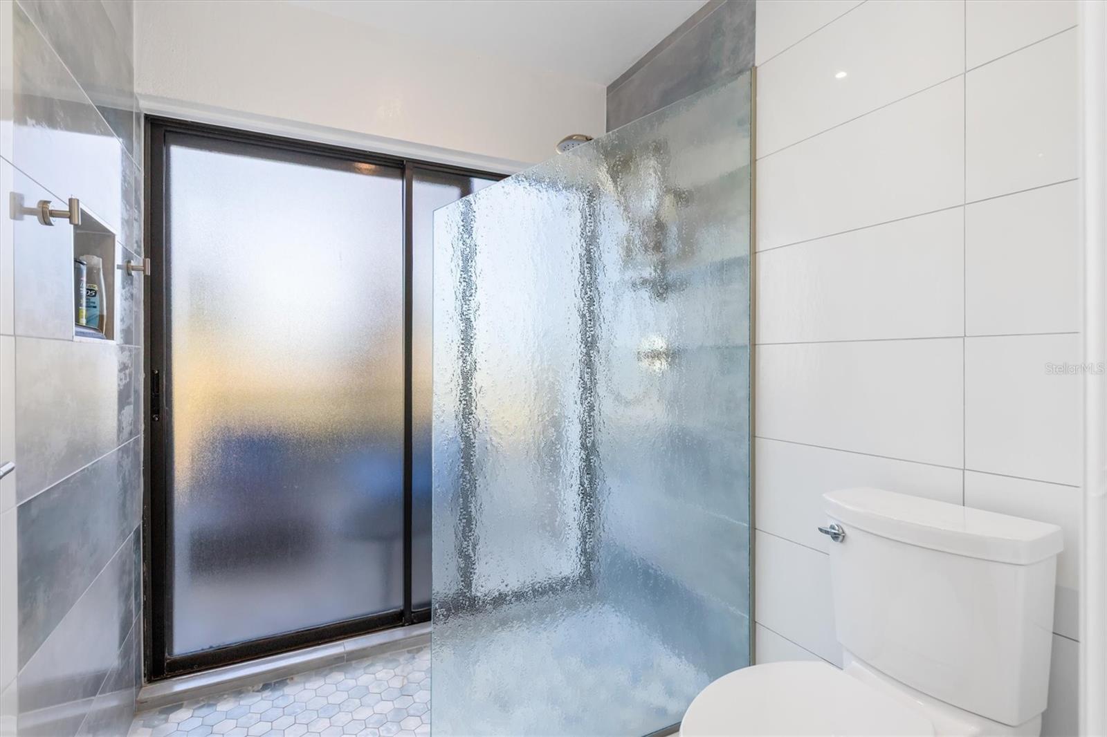 Glass shower and slider to lanai. Handy access for your hot tub.