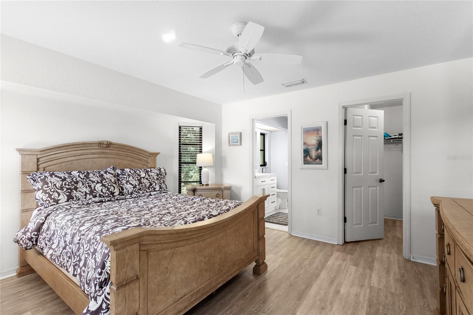 Primary Suite with laminate flooring and walk-in closet.