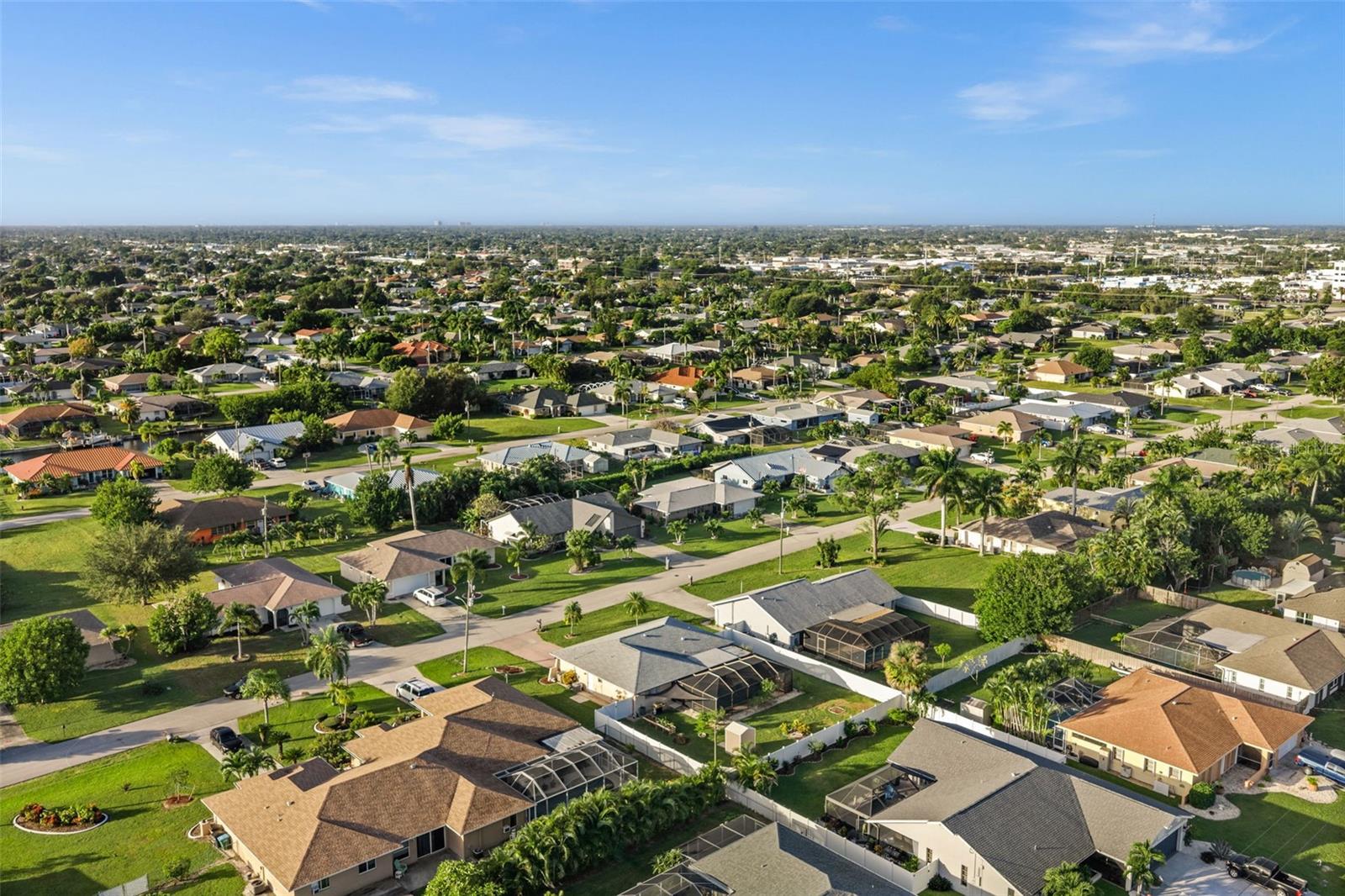 Perfectly positioned in a residential neighborhood featuring lush landscaping, mature palm trees, and established greenery.