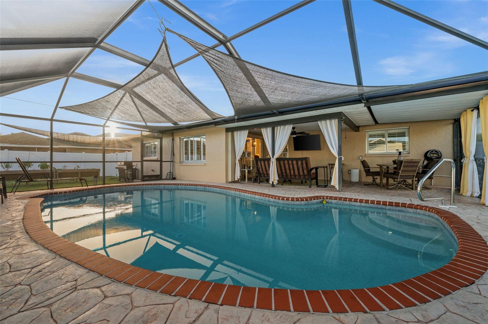 A newly screened lanai, a brick-paver bordered heated pool, and decorative sun shades. Home sweet home!