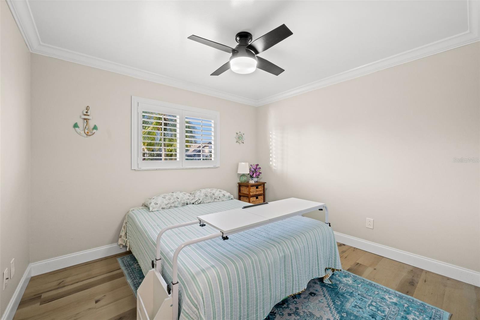 Neutral fresh paint, LVT flooring, modern lighting/fan, and again, plantation shutters in bedroom number 2.
