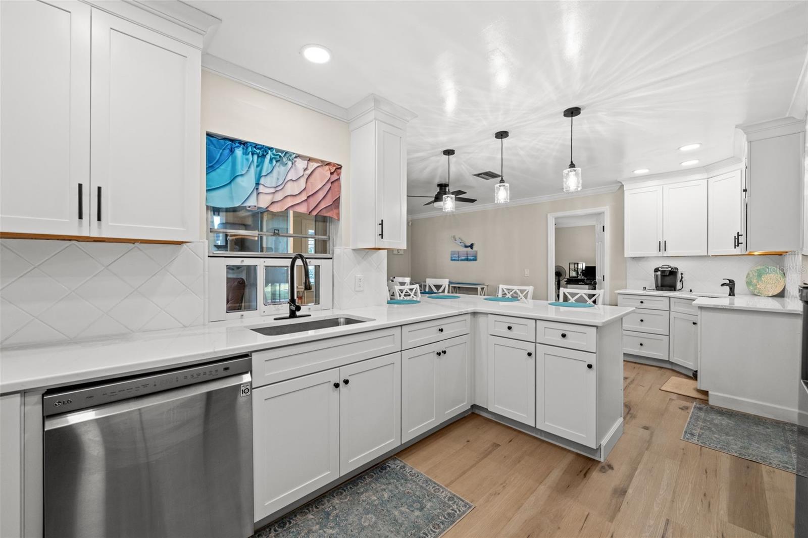Crown capped cabinetry molding, LVT flooring, and a window with a view.