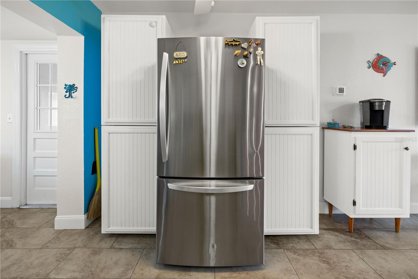 In addition to the cabinets in the kitchen, there is generous cabinet storage on the refrigerator side.