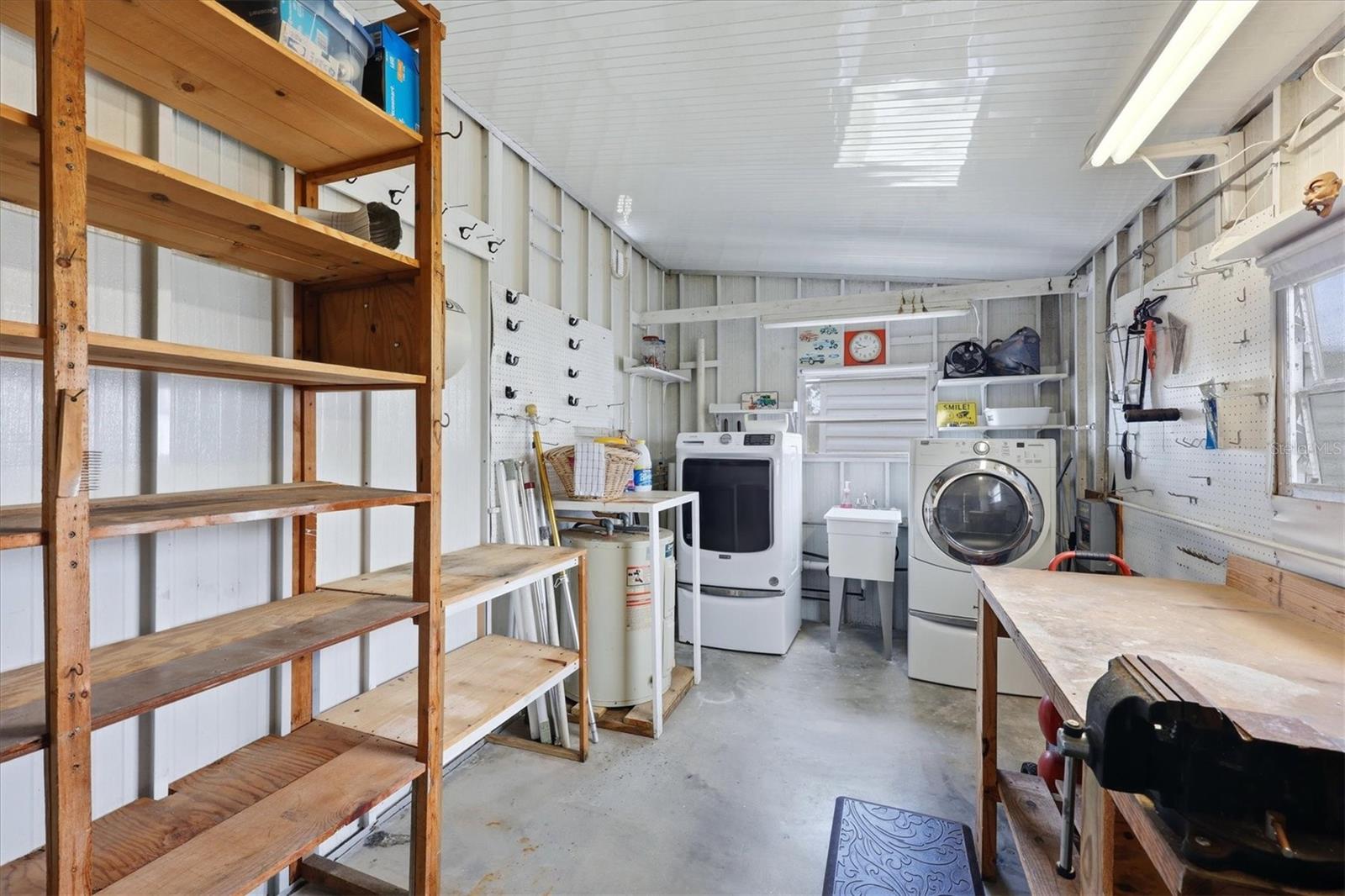 Enclosed Laundry room with workbench and storage