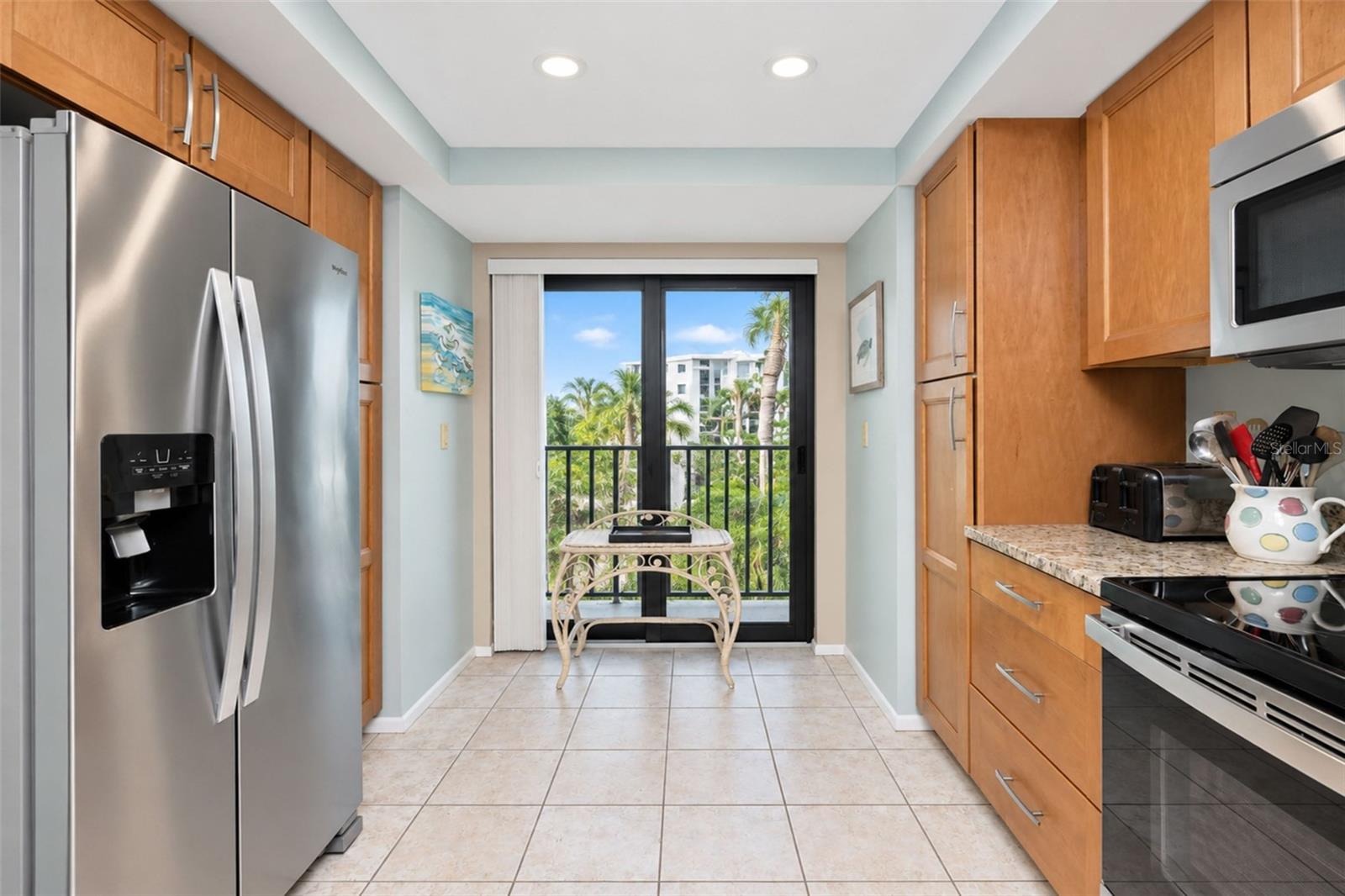 The kitchen has a stainless steel double door Whirlpool refrigerator and a French balony.