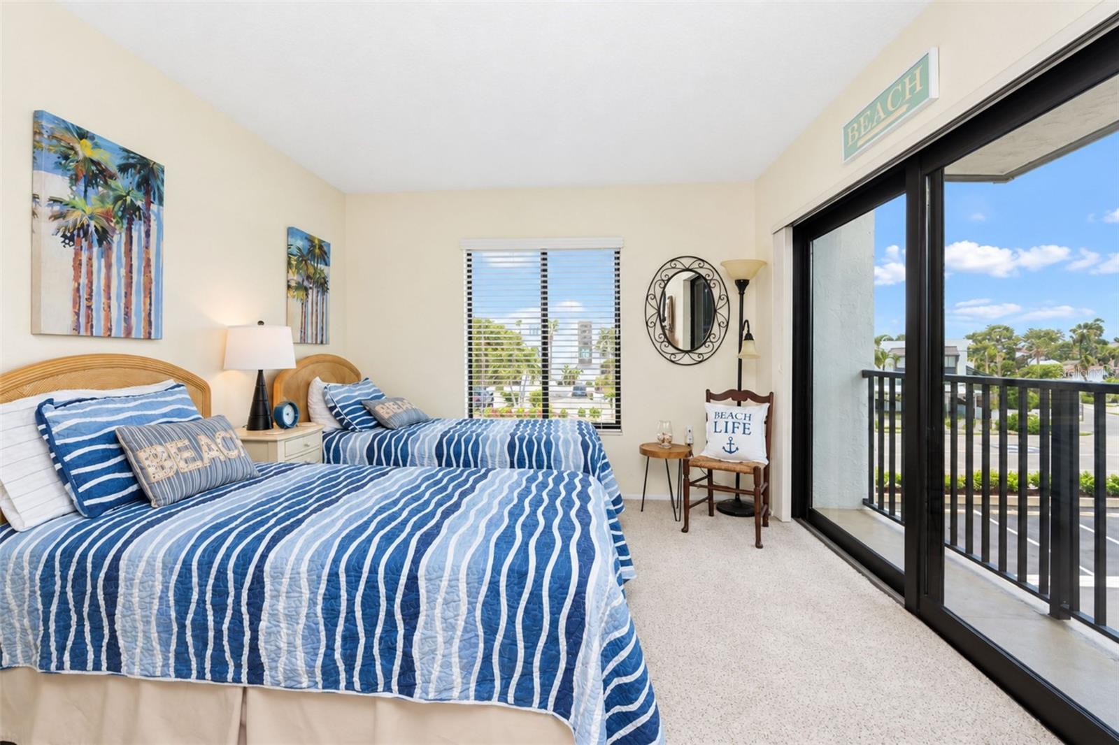The guest bedroom has carpeted flooring and impact sliding glass doors to the French balcony.