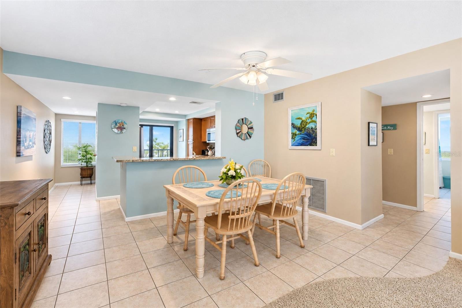 The dining room has tiled flooring and a ceiling fan with light. The dining room has tiled flooring and a ceiling fan with light.