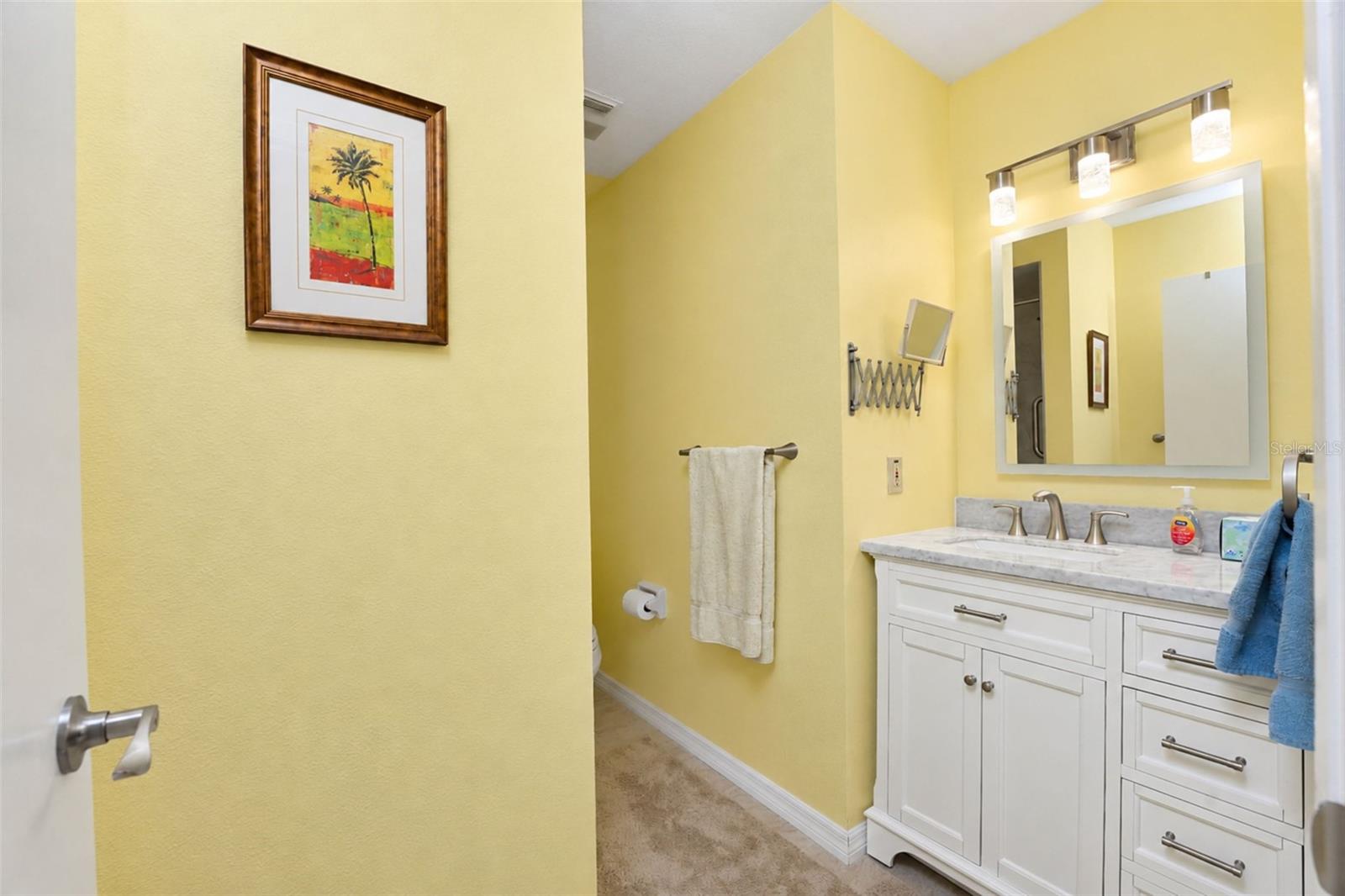 The guest bathroom has tiled flooring, new vanity with solid-surface countertop, new "touch" mirror, new lighting & many more updates!