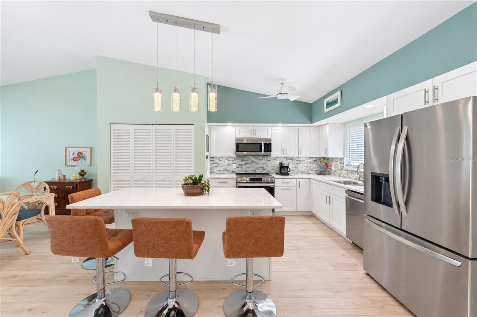 The kitchen island provides extra seating, beautiful pendant lighting and extra cabinetry.