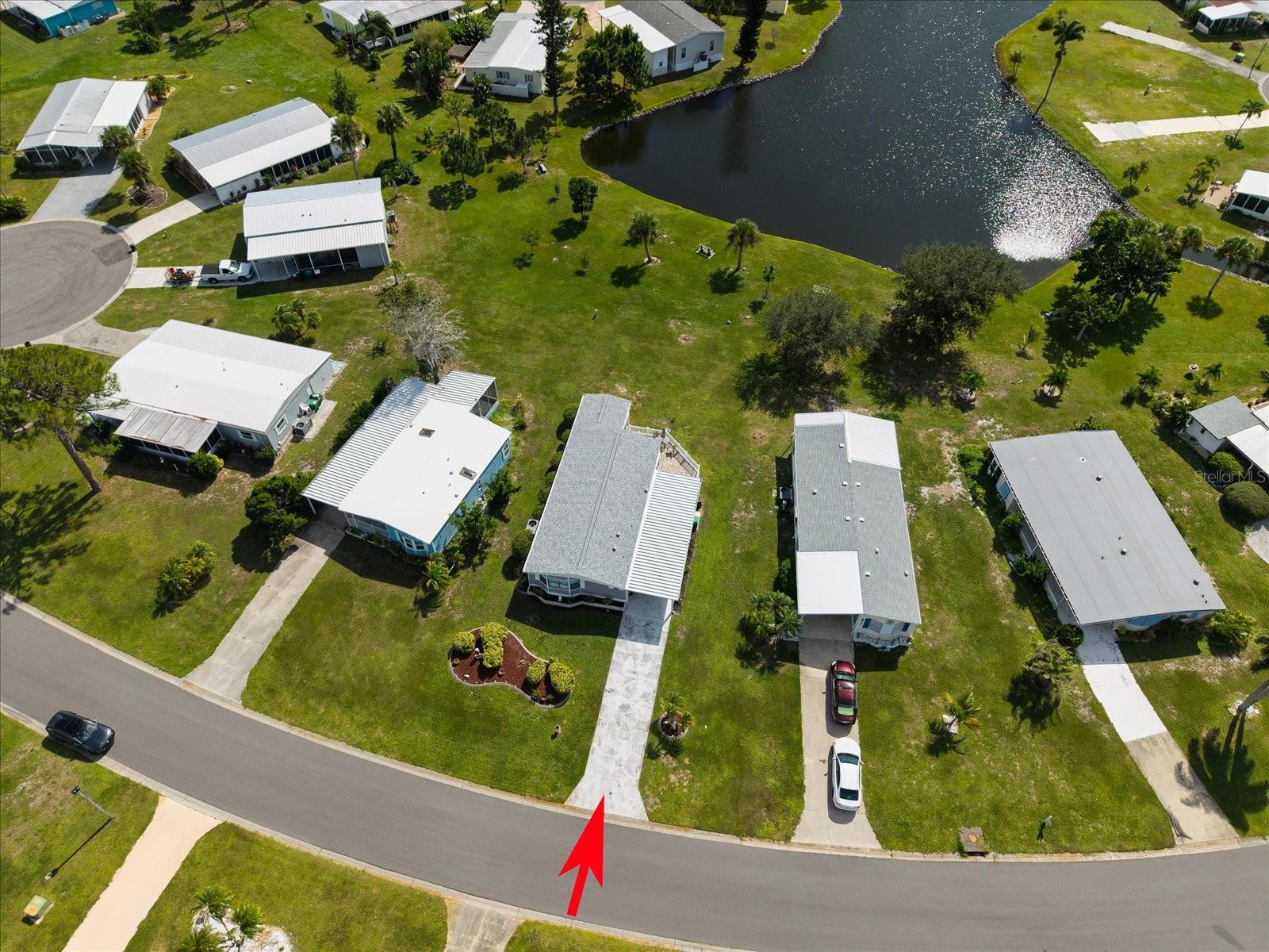 FRONT AERIAL VIEW OF THE PROPERTY AND POND.
