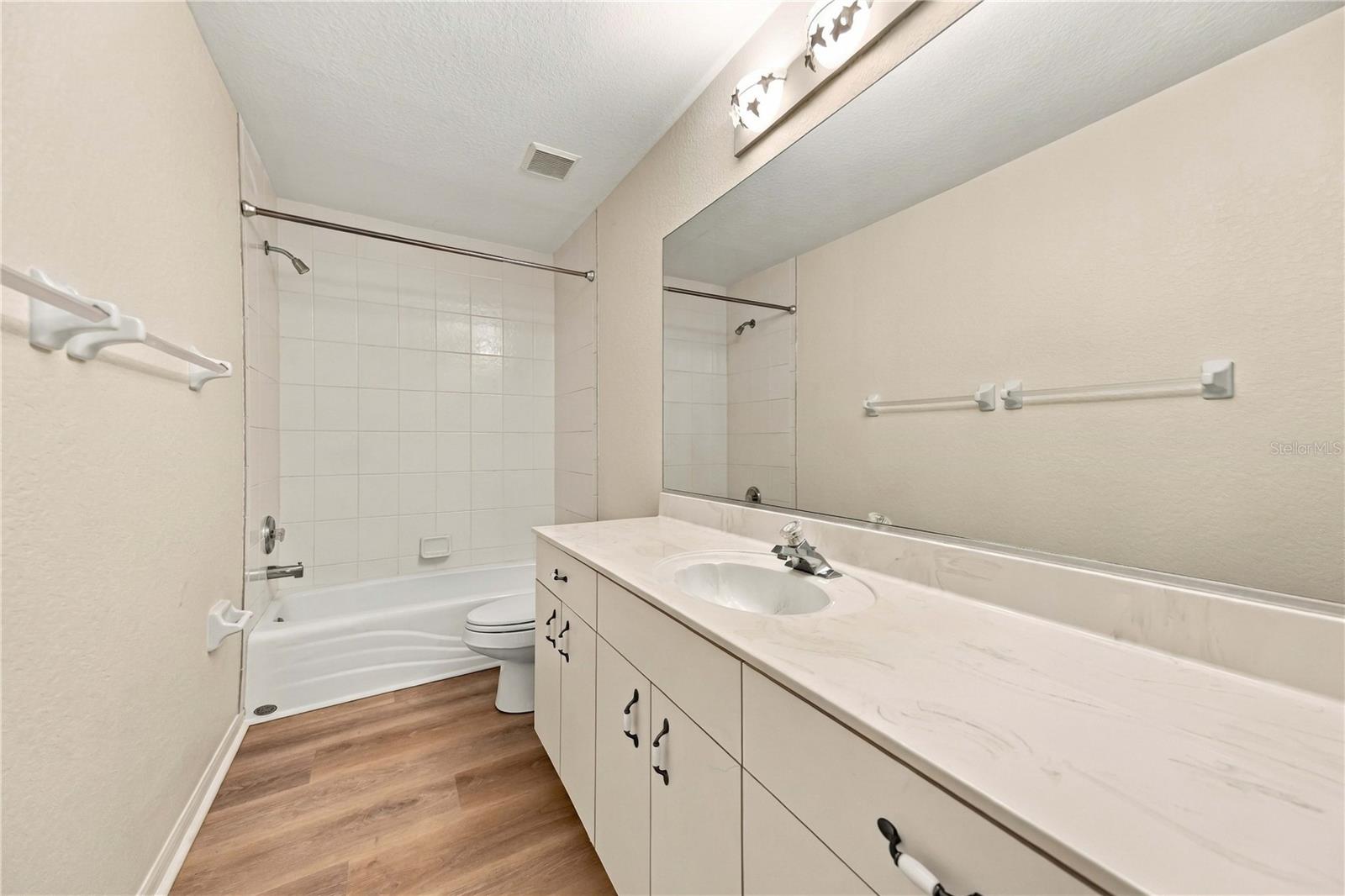 Hallway bathroom with tub/shower combo and double vanity