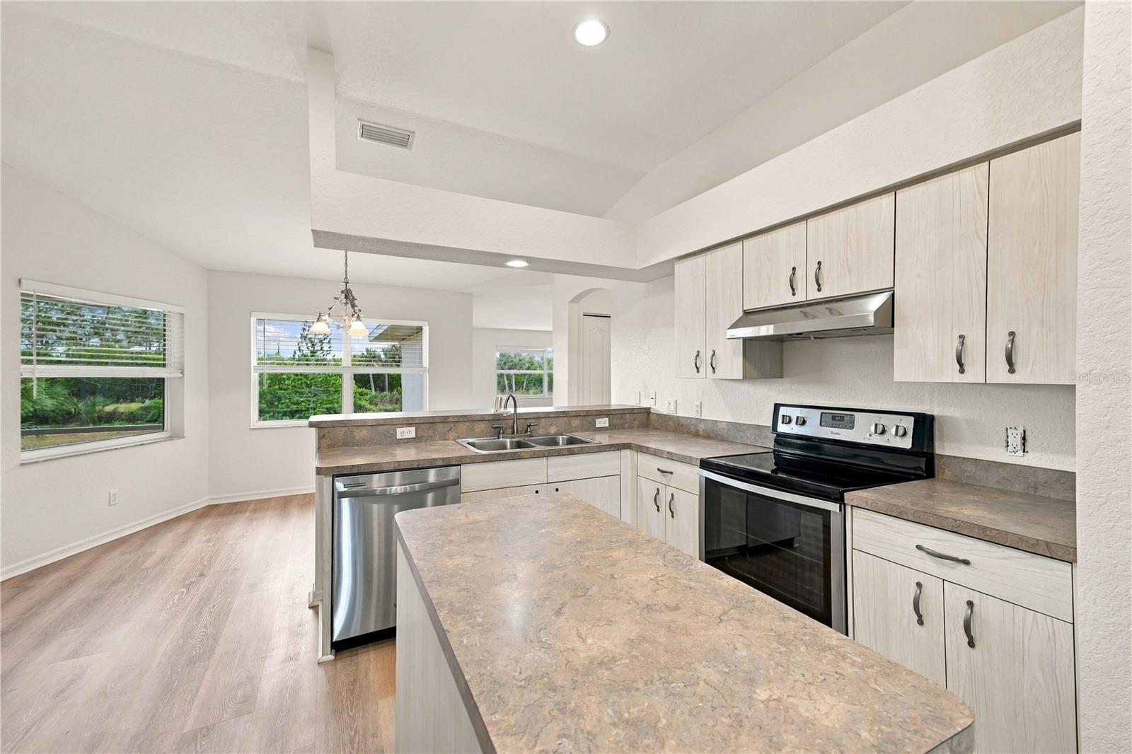 Kitchen island, granite-look counters, and bright windows