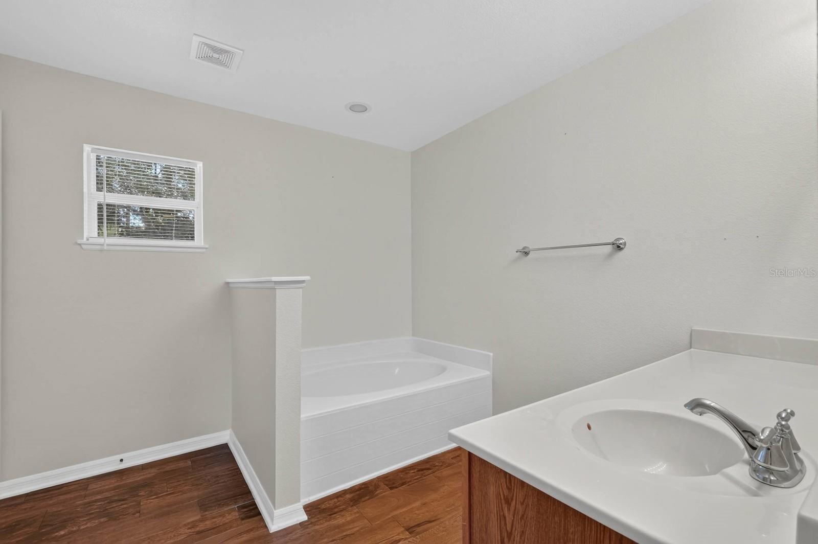 ensuite bathroom features soaking tub and separate shower