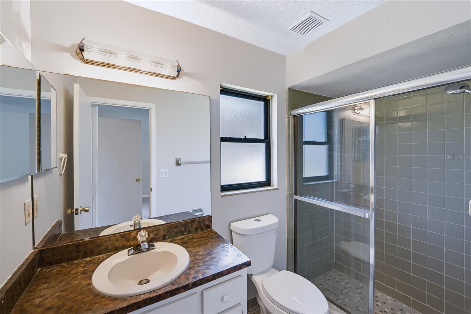 Master bathroom with shower, built-in medicine cabinet and retro-style glazed ceramic tile throughout