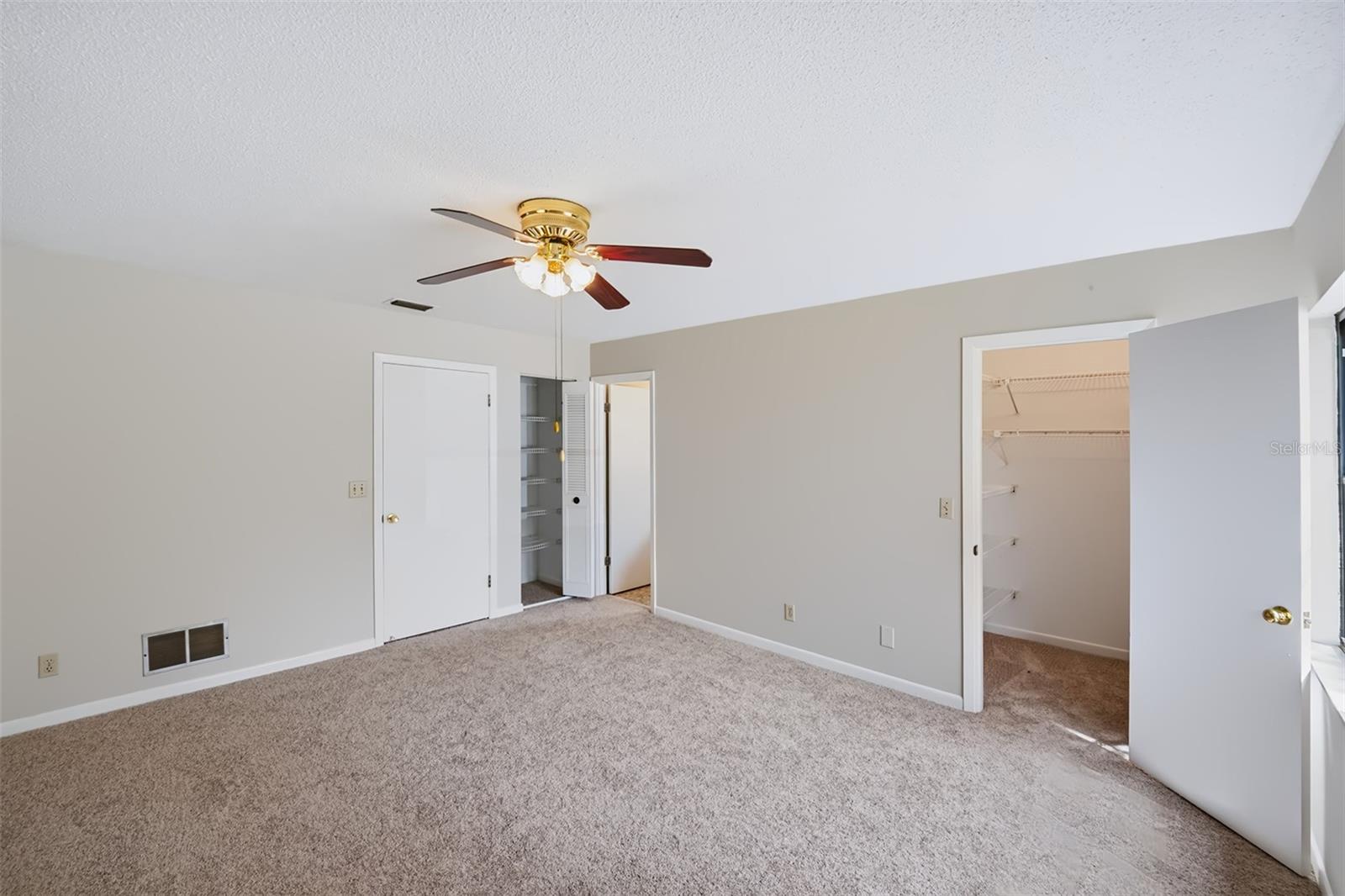 Master bedroom displaying the walk-in closet, and linen closet just outside the master bathroom