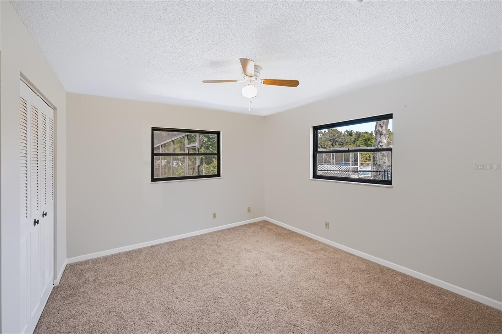 Secondary bedroom with double walk-in closets and view overlooking the pool/canal area