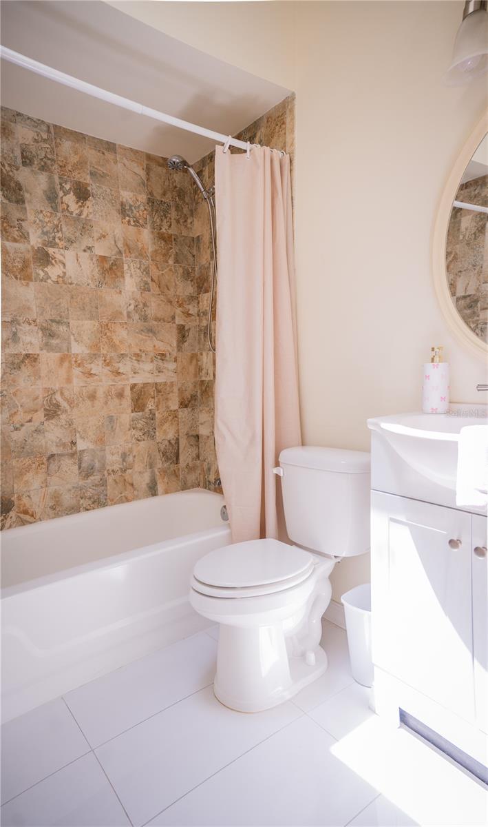 Second bathroom featuring a modern vanity, updated fixtures, and a fully tiled shower.