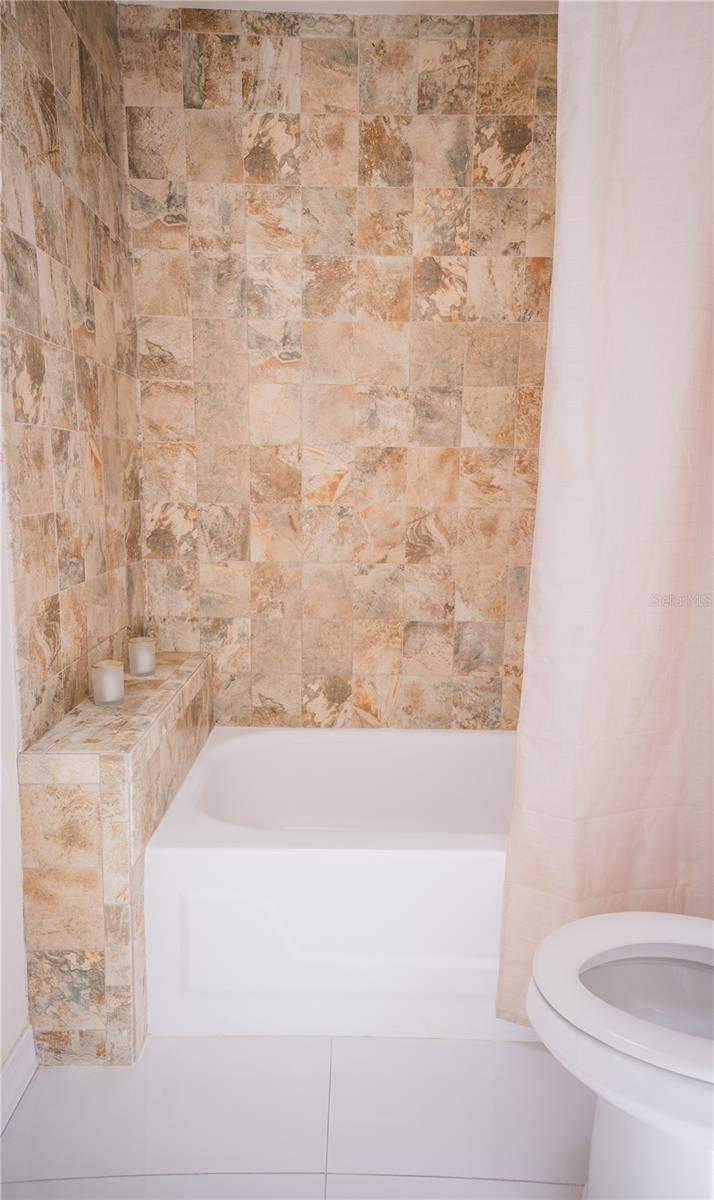 Beautifully tiled secondary bathroom featuring modern finishes and updated fixtures.