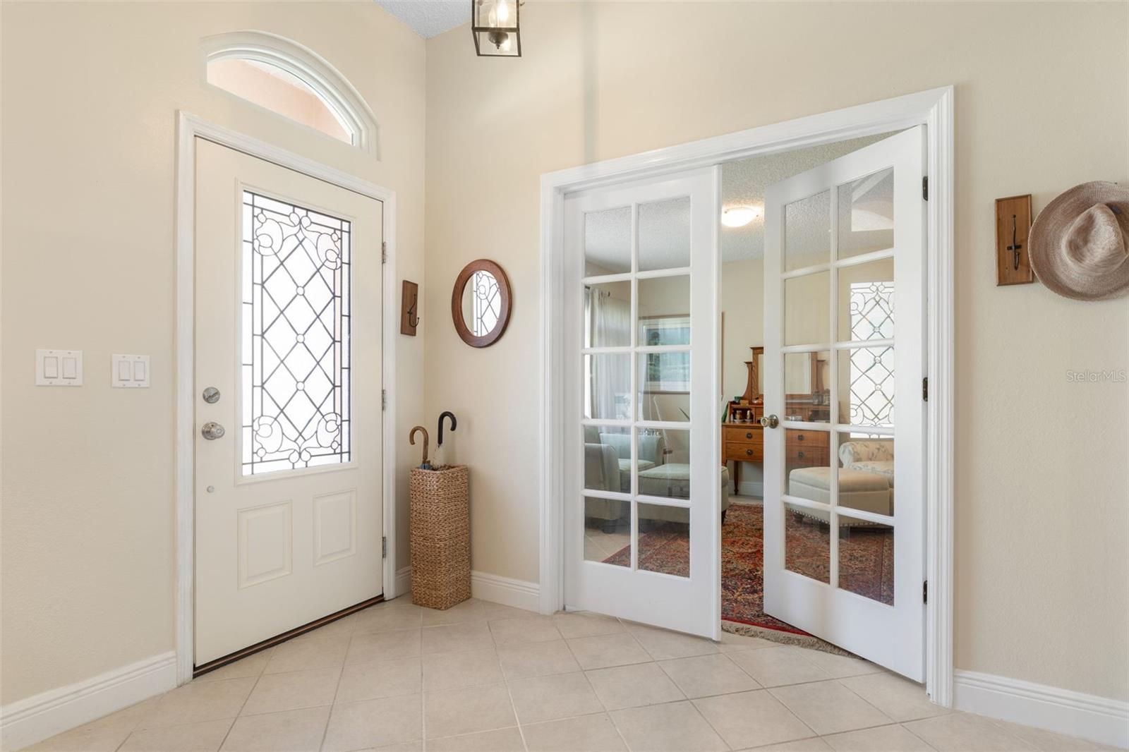 First impressions matter! This lovely foyer features a decorative glass entry door, elegant transom window, and French doors that offer a peek into the adjoining den/office, setting a gracious tone from the moment you arrive