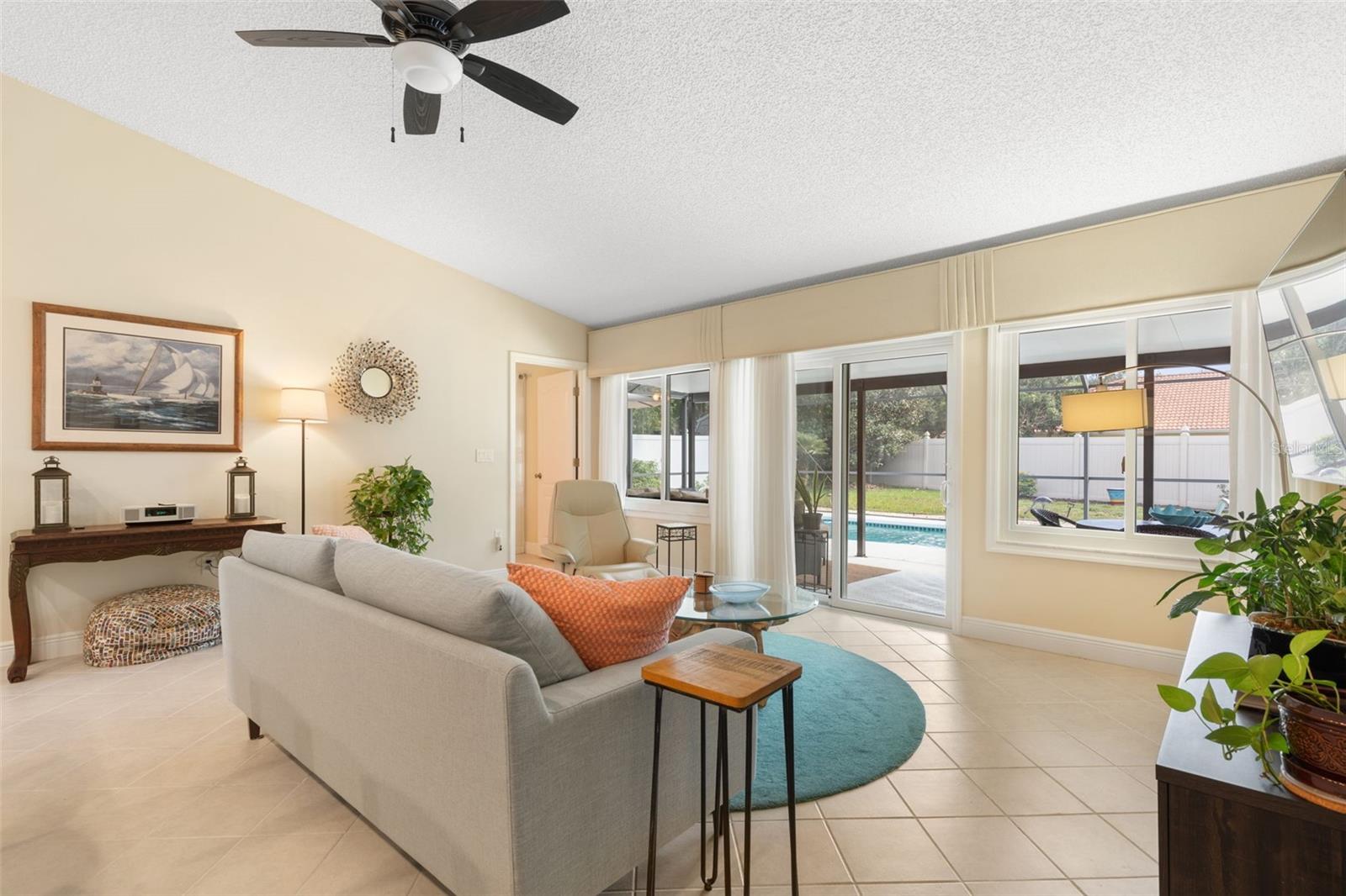 Just a few steps from the sofa, the sparkling pool beckons! Expansive windows and sliding glass doors bring the Florida sunshine indoors, making it easy to slip outside for a refreshing swim whenever the mood strikes.