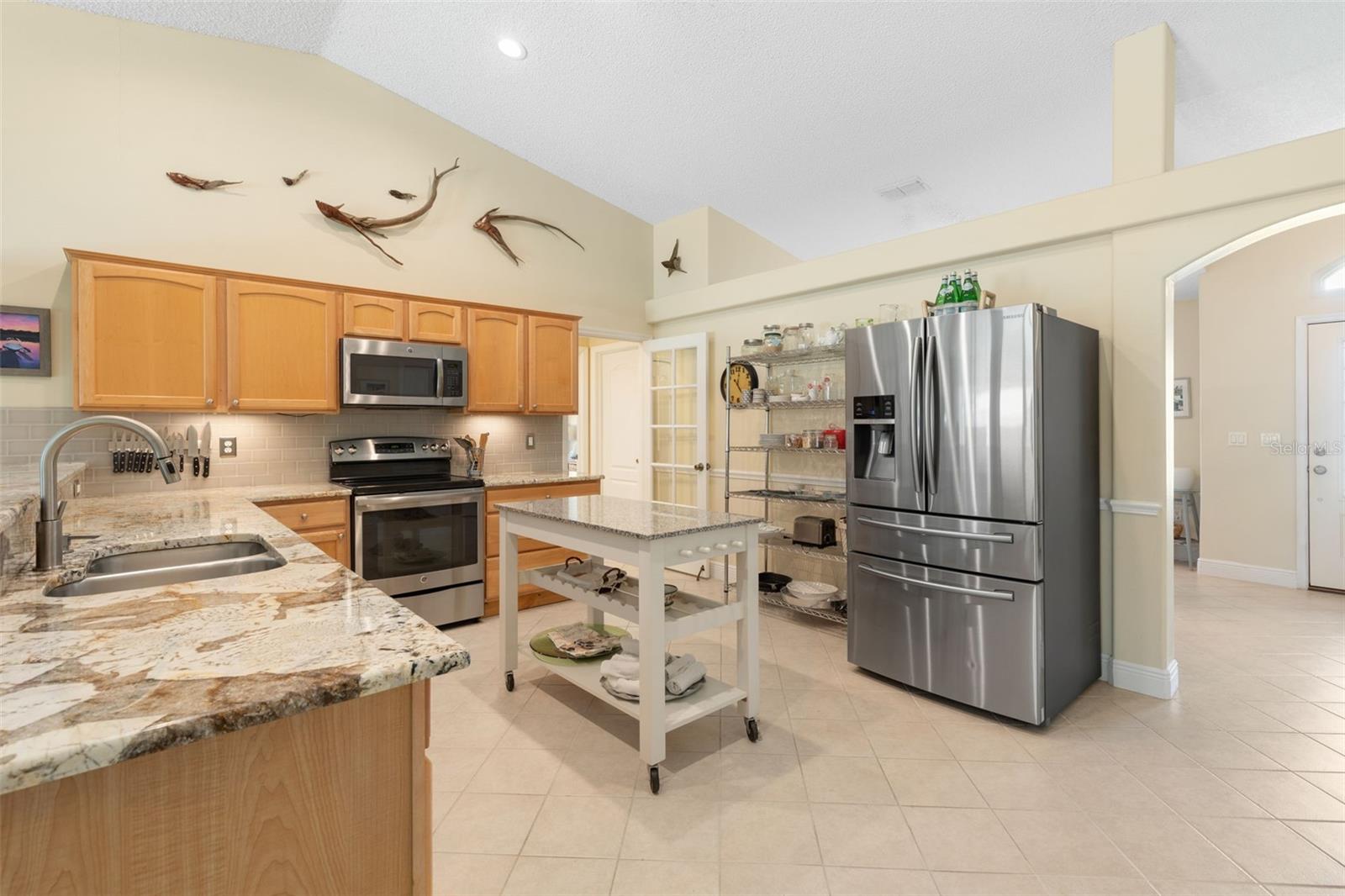 From preparing family favorites to trying new recipes, this kitchen makes everyday cooking a pleasure with beautiful granite countertops, stainless steel appliances, warm wood cabinetry, and a convenient movable island for added versatility.
