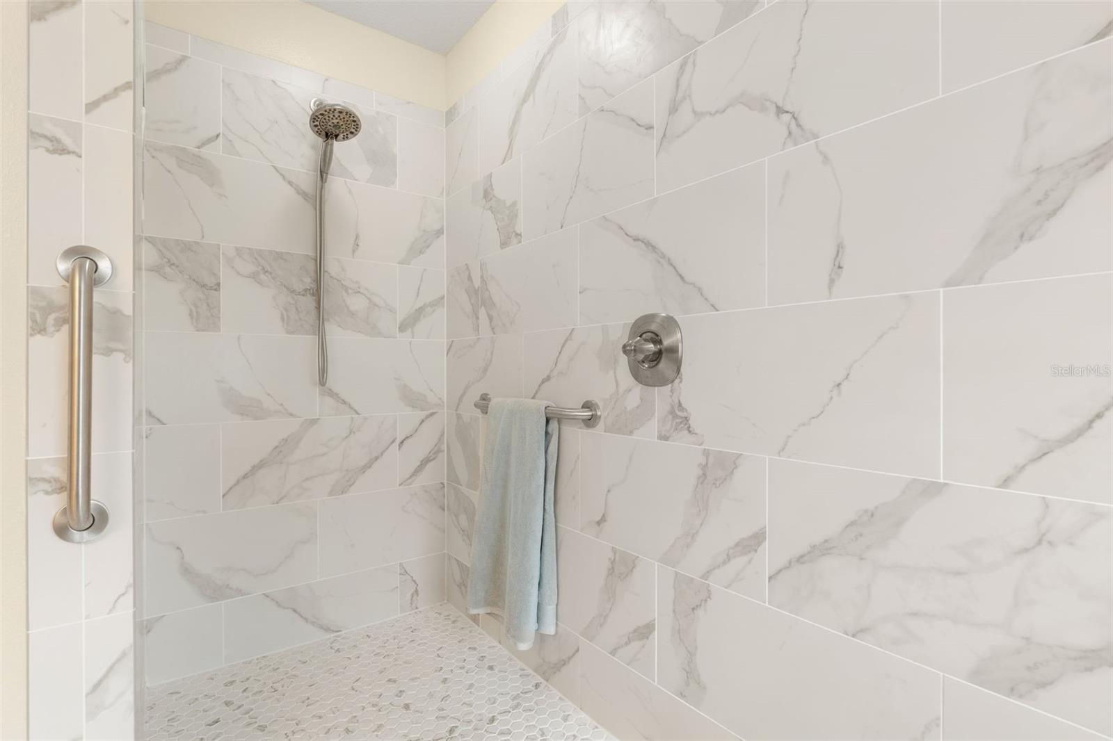 A little luxury goes a long way! The primary shower's generous walk-in design and convenient grab bar combine beautiful style with everyday practicality.