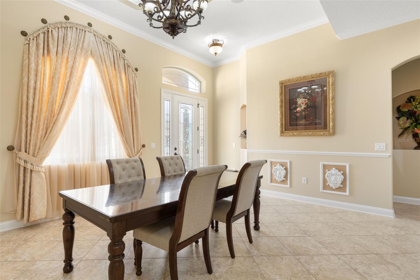 Beautiful window treatments, decorative wall molding and soft natural light create a welcoming atmosphere for memorable dinners and special occasions.