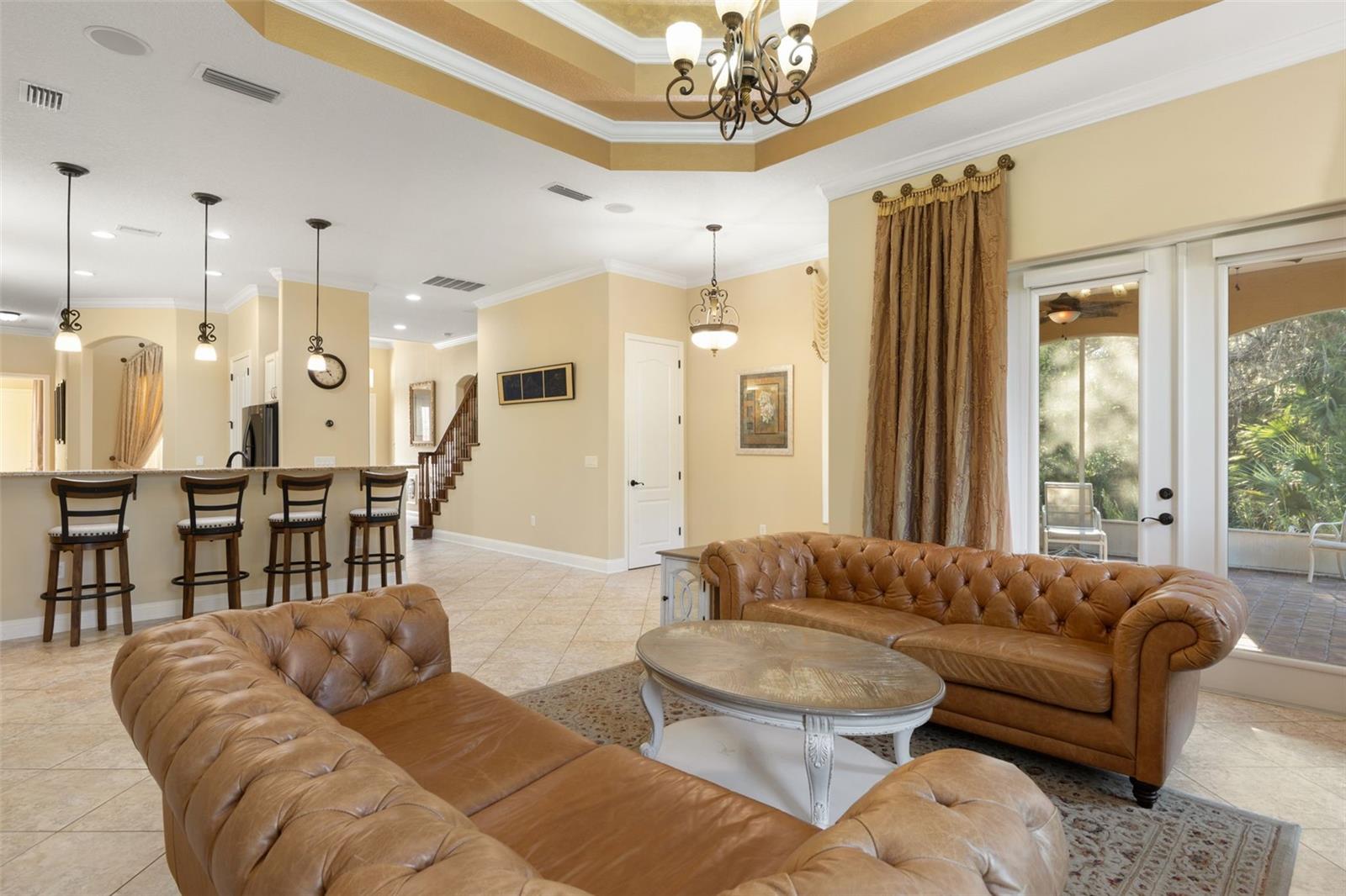 French doors open to the screened lanai, while the adjoining kitchen and breakfast bar create a natural flow for everyday living and entertaining.