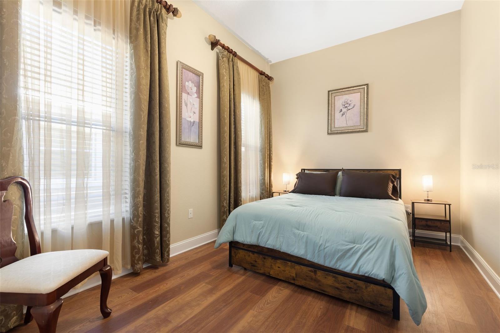 First-Floor Bedroom #2 offers a tranquil, comfortable retreat with warm wood-look flooring and a peaceful atmosphere.