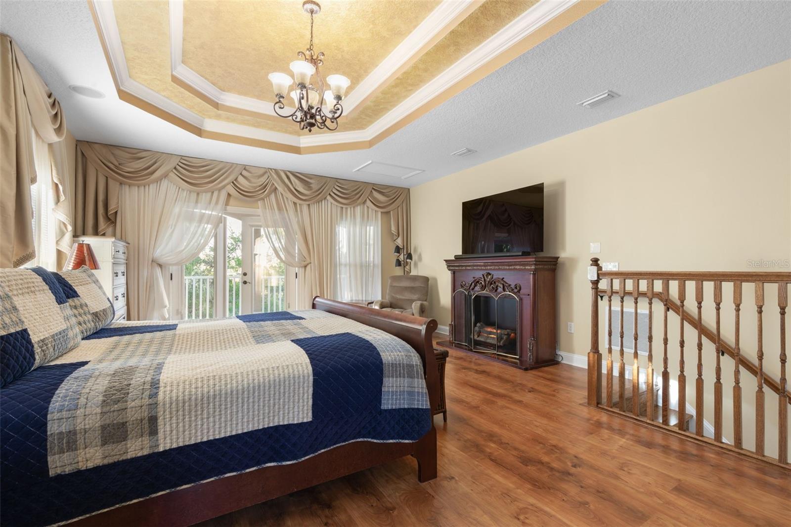French doors open to a private balcony overlooking the wooded surroundings, offering a peaceful escape just steps from the bedroom.