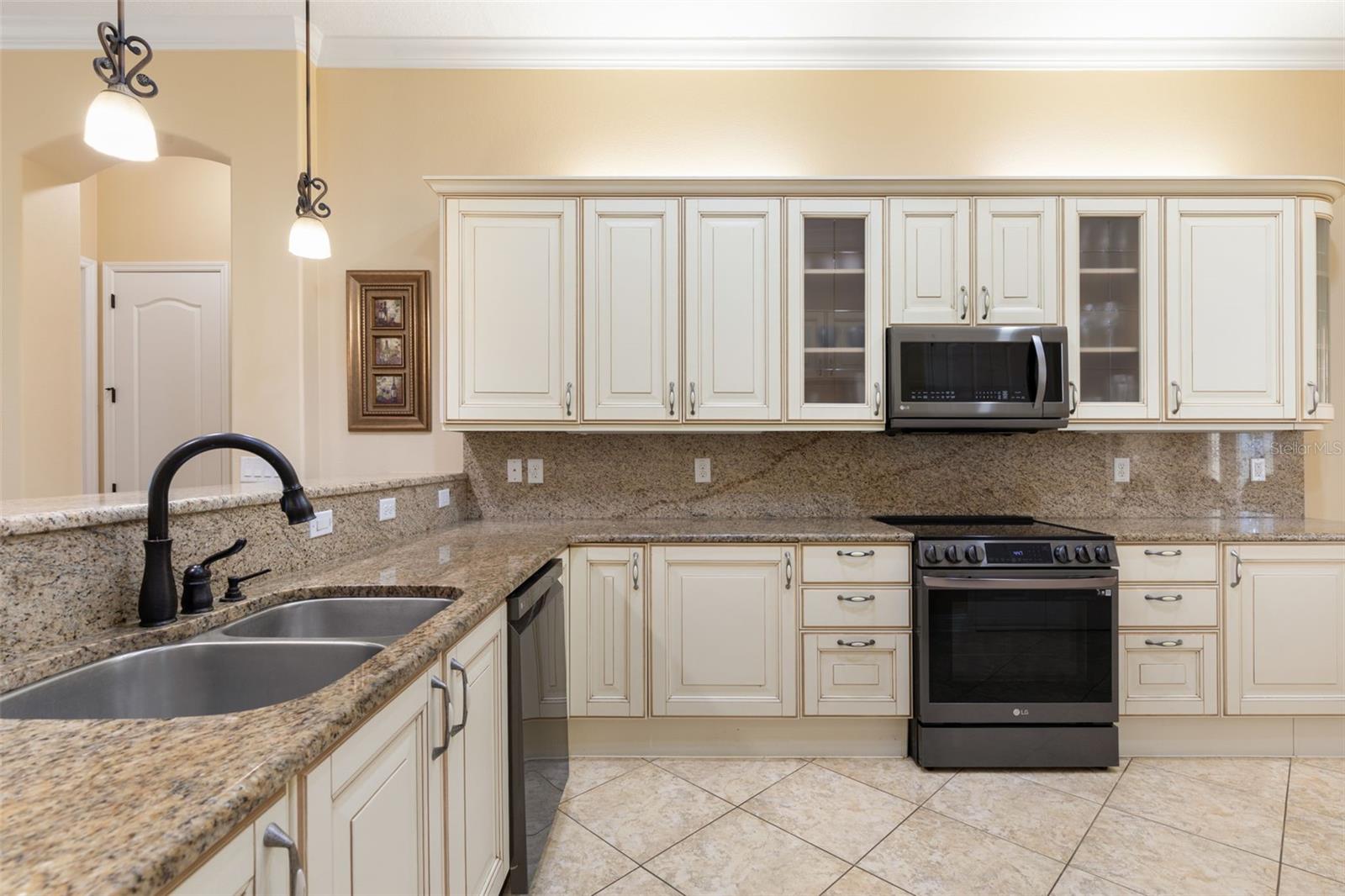 Italian-inspired cabinetry, granite countertops and matching backsplash bring timeless elegance to this beautifully designed kitchen.