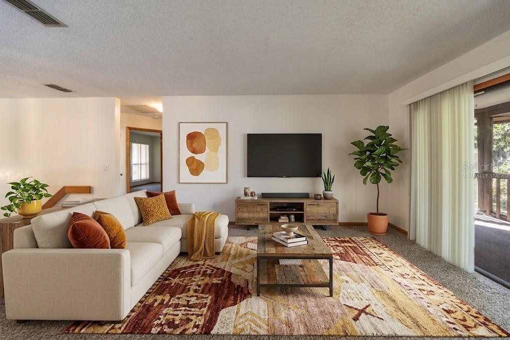 VIRTUALLY STAGED: Living Area With Sliders That Open Into The Screened Patio
