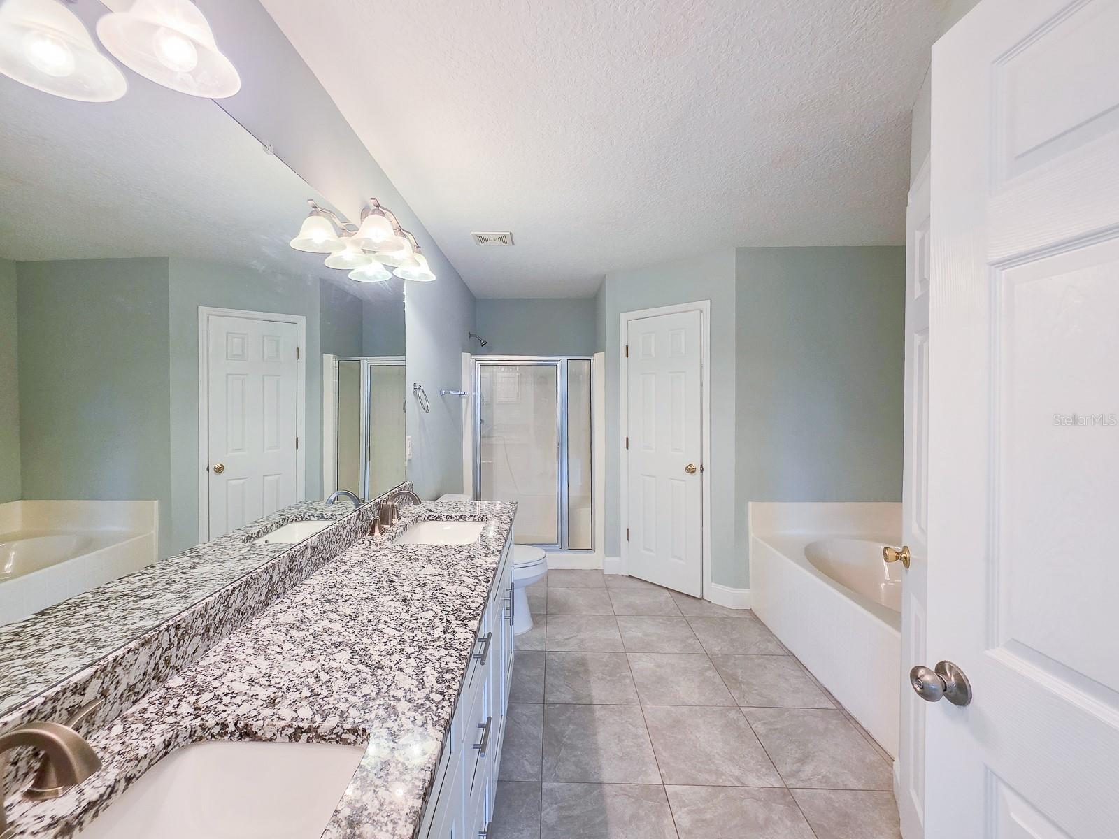 Primary bath with soaking tub, shower, double sinks, granite tops and his and hers closets