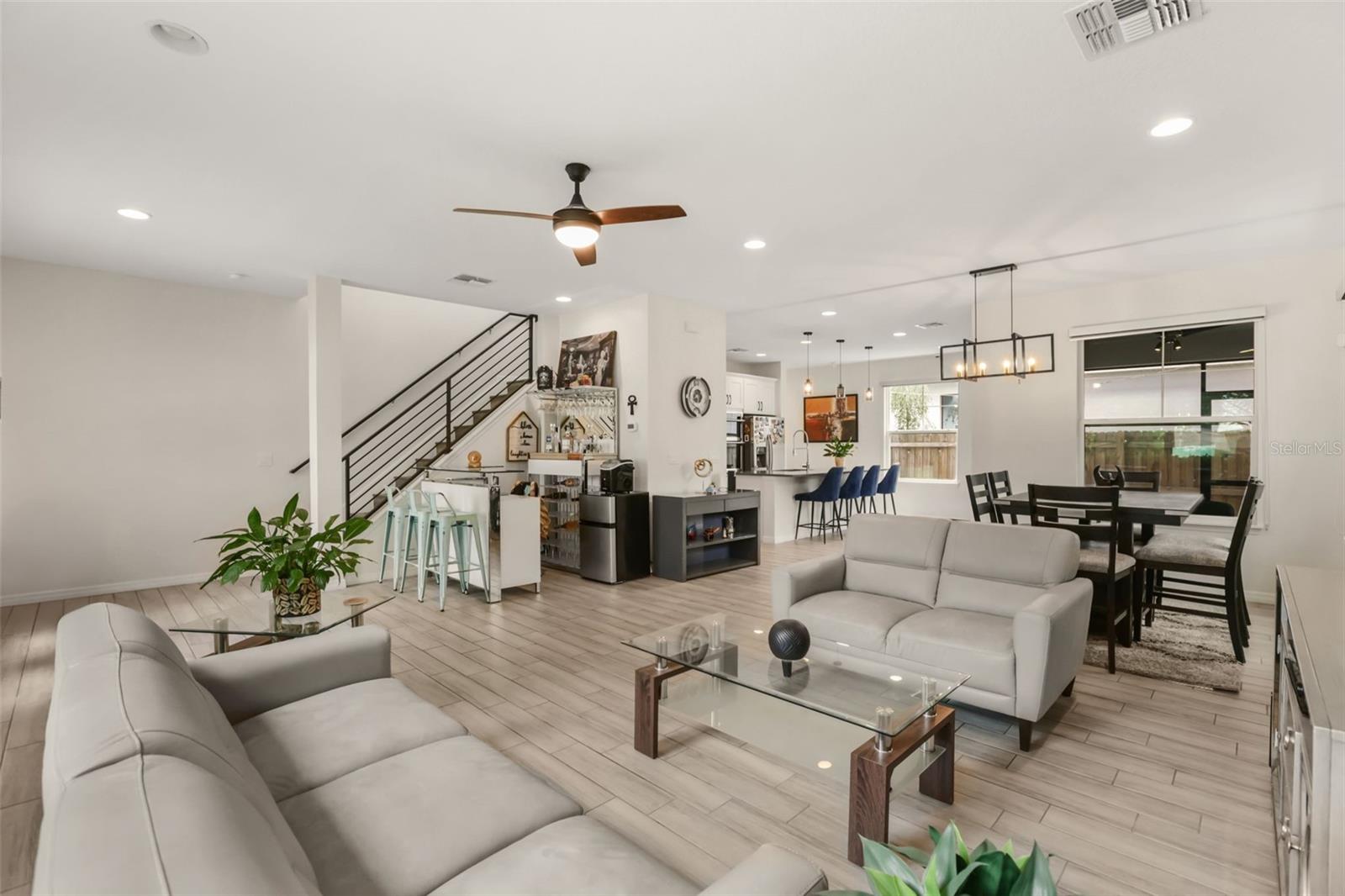 Bright open concept living room featuring high ceilings, abundant natural light, and seamless flow to the dining area and kitchen. Bright open concept living room featuring high ceilings, abundant natural light, and seamless flow to the dining area and kitchen.