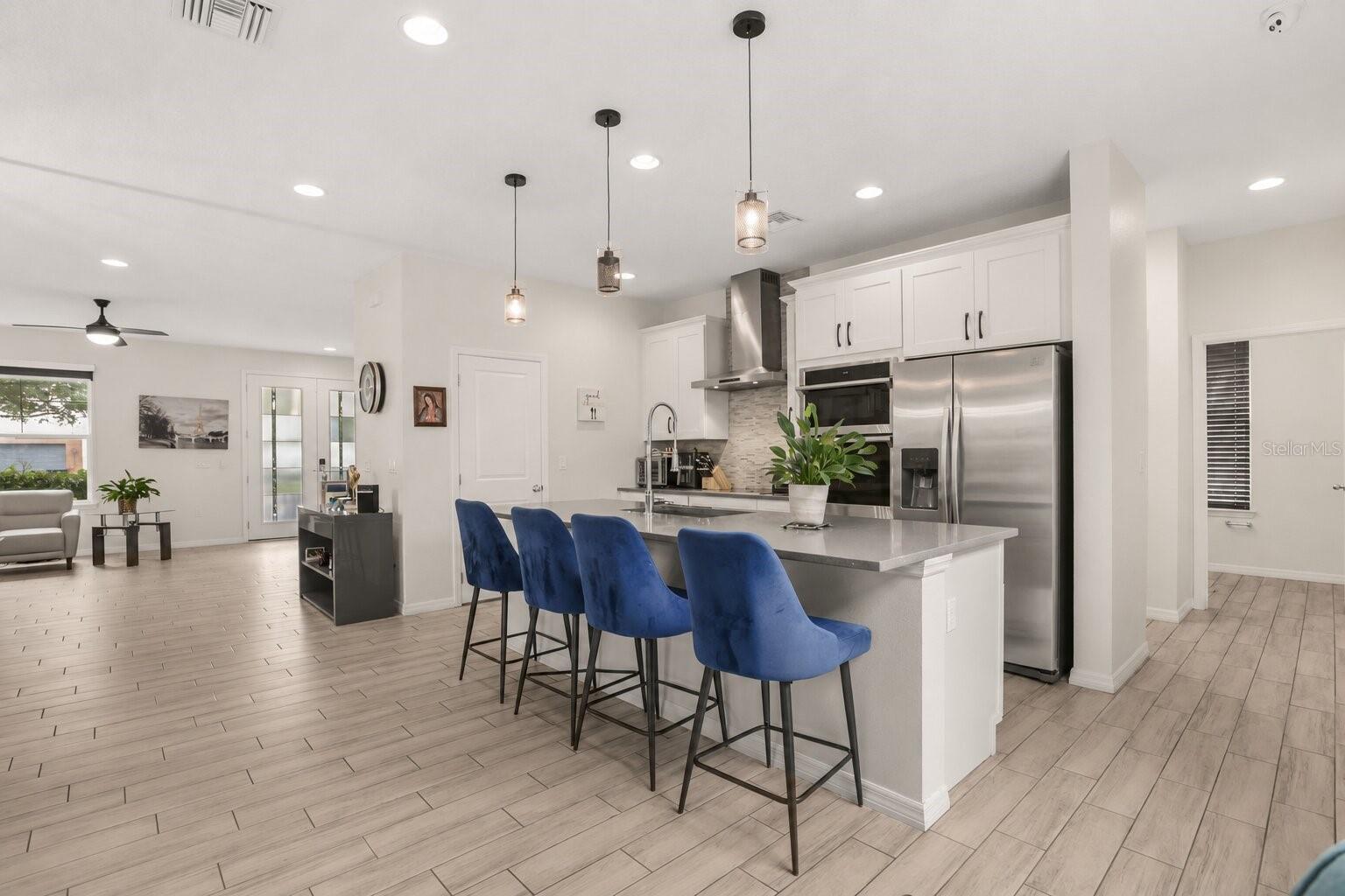 Alternate view of the spacious kitchen showcasing the oversized center island with seating and its seamless connection to the open living areas. Alternate view of the spacious kitchen showcasing the oversized center island with seating and its seamless connection to the open living areas.