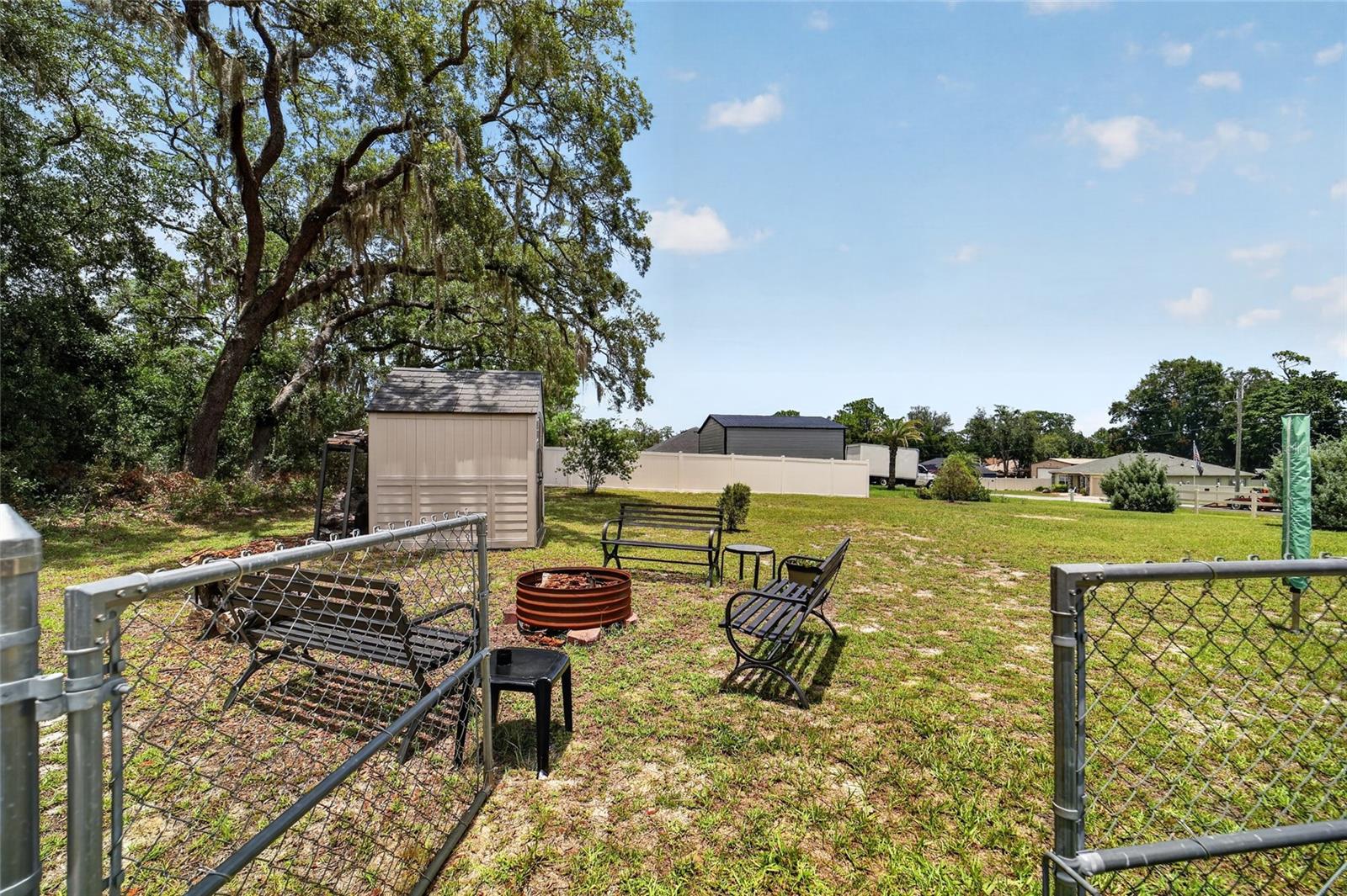 Gate to extra lot with fire pit and additional shed
